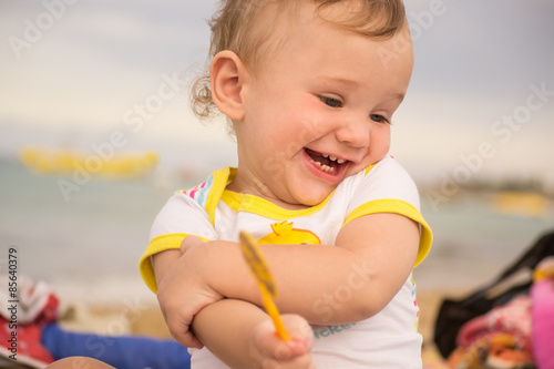 Small child with redness on the skin, suffering from food allergies by the sea