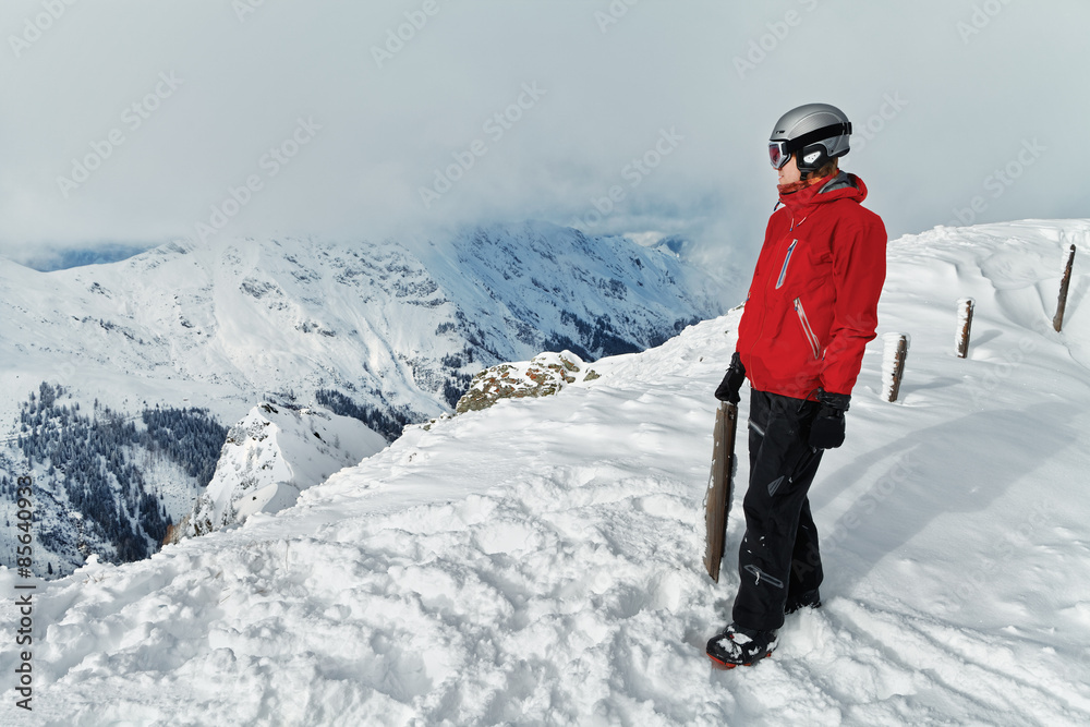 Male snowboarder against panoramic winter mountains background