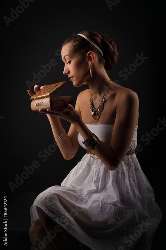 Cuadro en lienzo A girl acting Pandora as she opens the box
