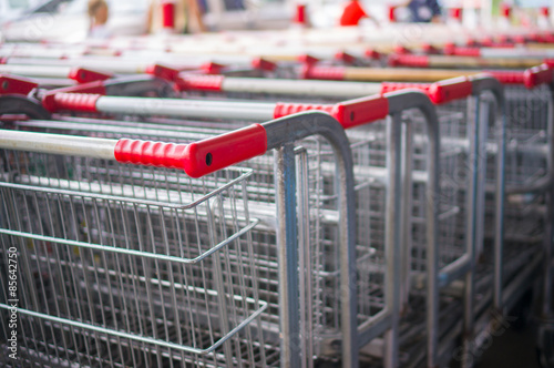 Rows of heavy shopping carts at the entrance of supermarket