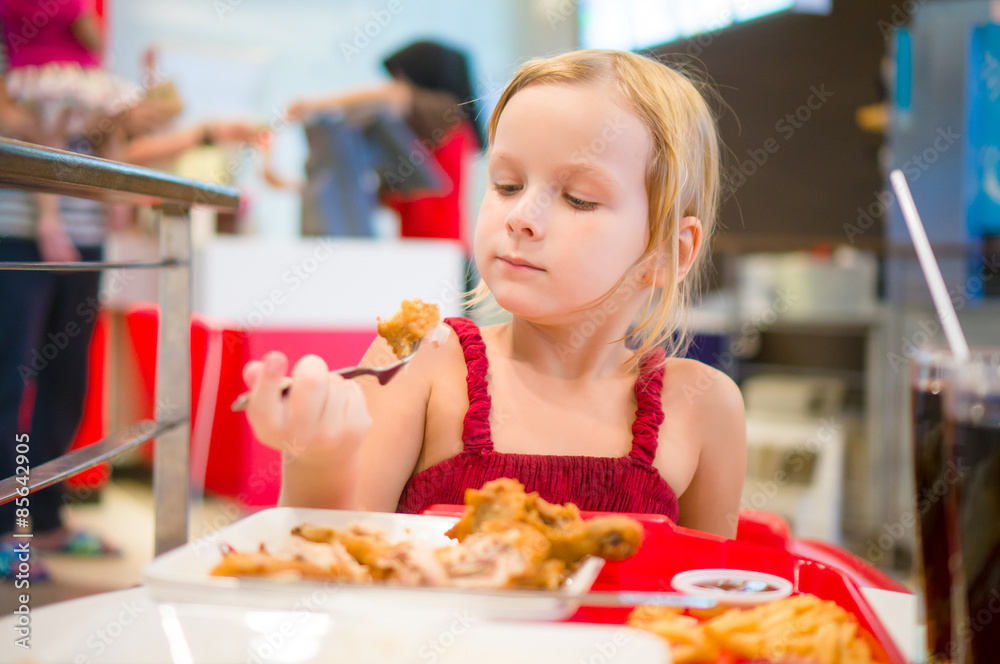 Adorable girl have meal with chicken, soda drink and fried pota Adorable girl have meal with chicken, soda drink and fried pota