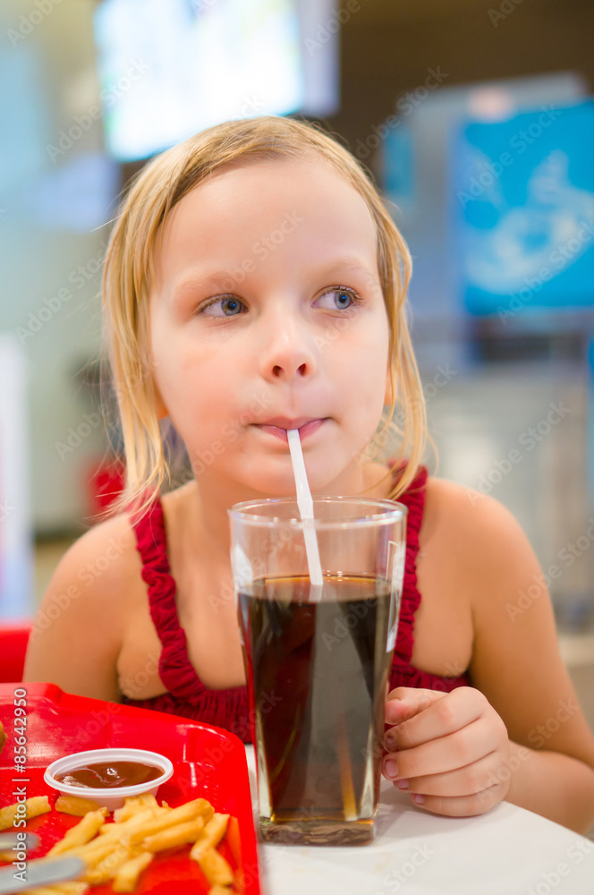 Adorable girl have meal with chicken, soda drink and fried pota Adorable girl have meal with chicken, soda drink and fried pota