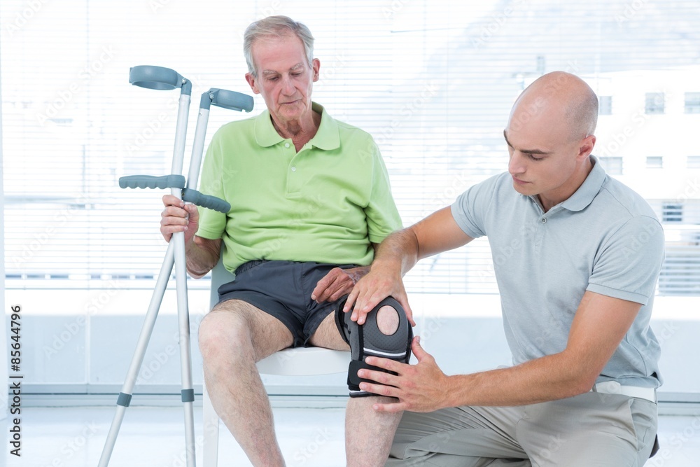 Doctor examining his patient knee Doctor examining his patient knee