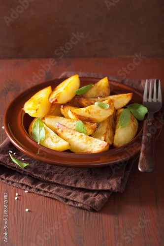 baked potato wedges in plate over brown rustic table