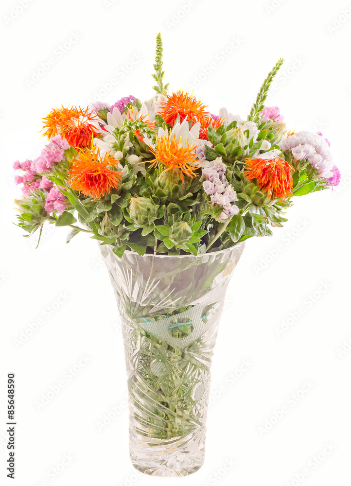 Vivid colored wild flowers in a transparent vase, close up