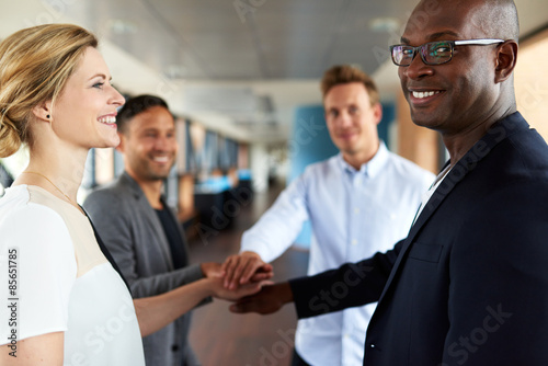 Group of young executives smiling before teamwork