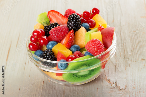 bowl of fruit salad isolated on wood table