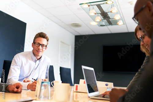 White male executive smiling at camera during meeting