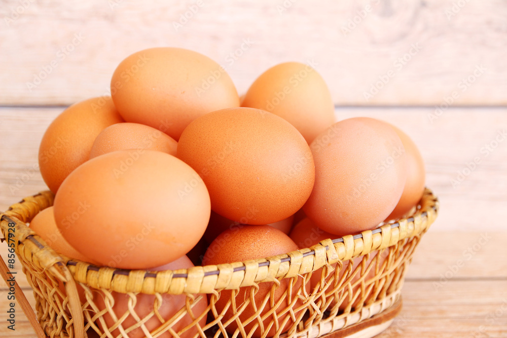 Eggs in the basket on wooden background Eggs in the basket on wooden background
