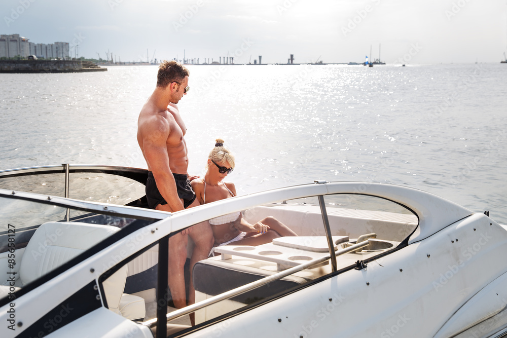 Elegant beautiful couple on a boat in a swim wear