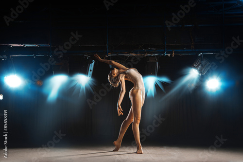 Beautiful adult ballerina on stage posing
