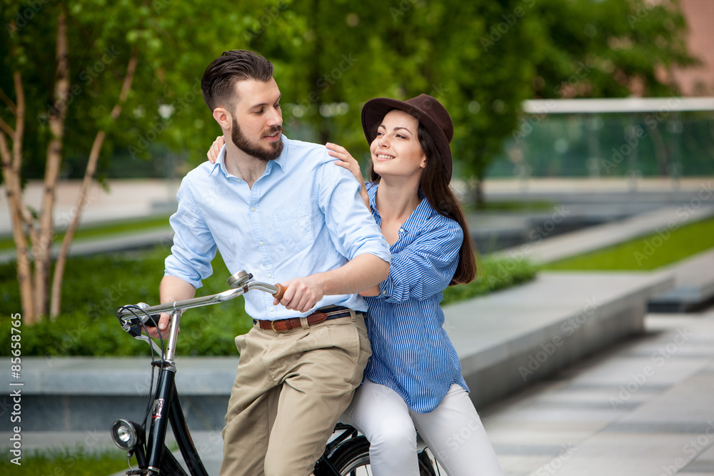 Obraz premium Young couple sitting on a bicycle