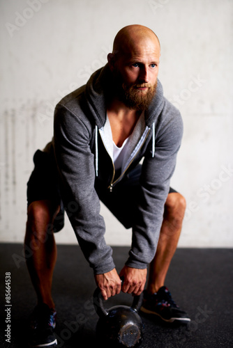 Strong athletic white man in gym with kettlebell © Flamingo Images