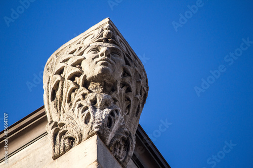 Building Corner Head Closeup - Majestic Looking Head Perched High On the Corner of a Brown Stone Building photo