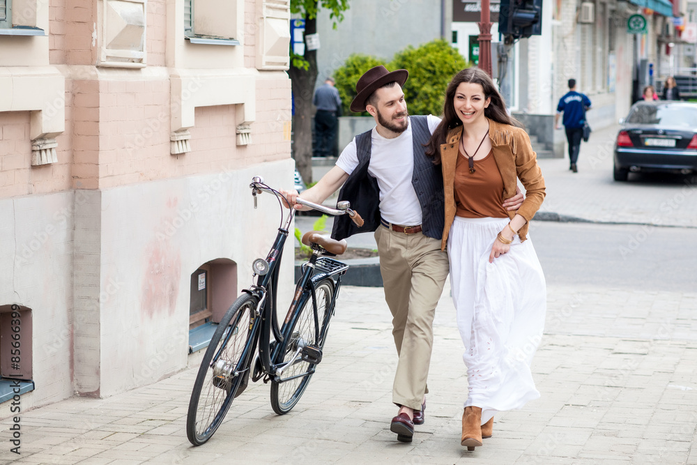Young couple walking with bicycle and hugging Young couple walking with bicycle and hugging