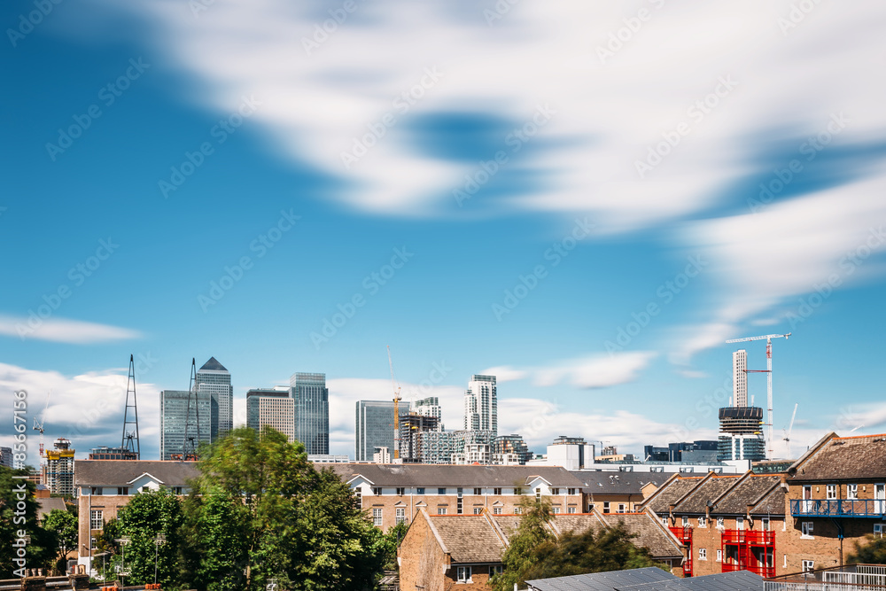 Long exposure cityscape of Canary Wharf / London Financial District viewed from Isle of Dogs on a sunny day