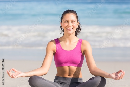 Fit woman doing yoga beside the sea 