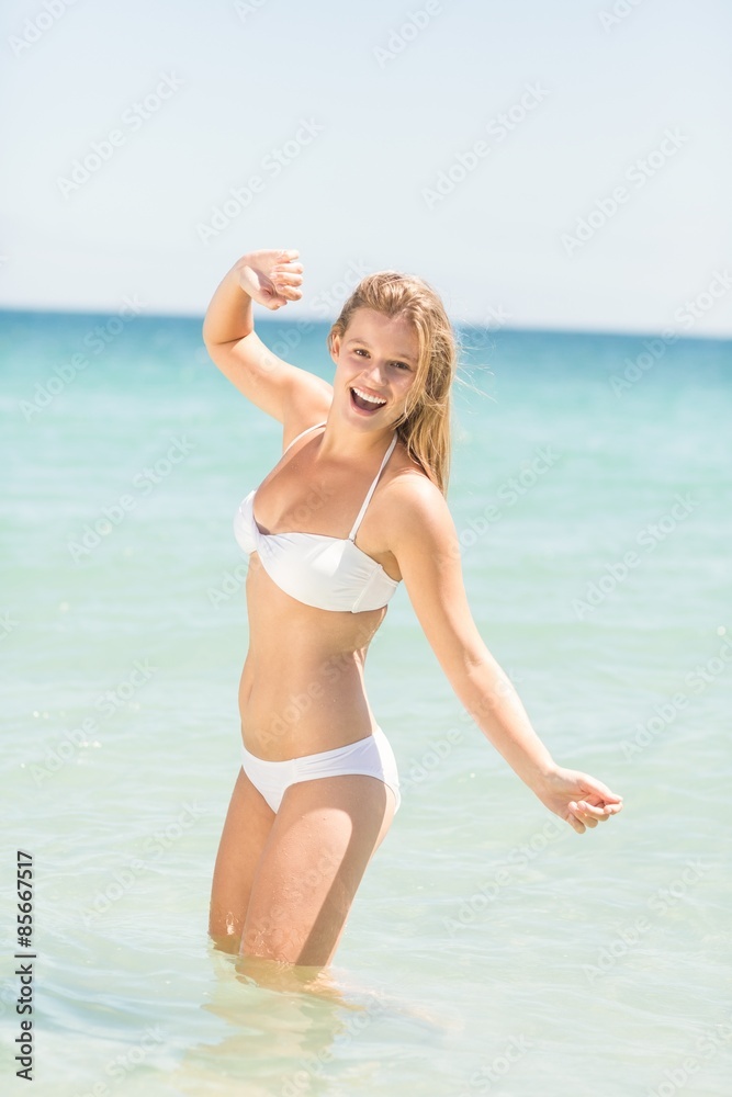 Happy pretty blonde looking at camera into the sea
