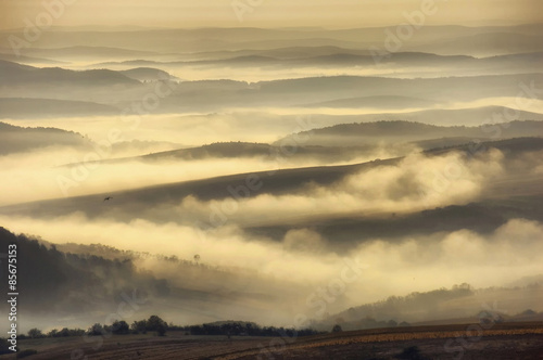 fog through hills on autumn morning