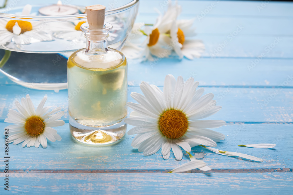 Chamomile flowers and bottle with aroma oil Chamomile flowers and bottle with aroma oil