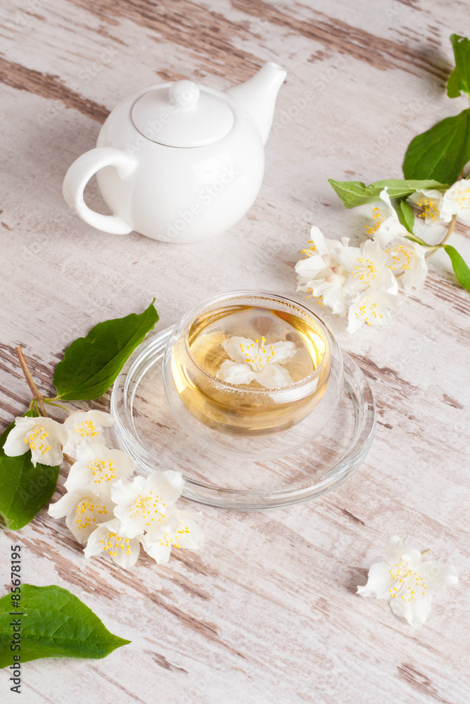 Glass cup of green tea with jasmine on wooden background Glass cup of green tea with jasmine on wooden background