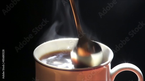 heisser kaffee in kaffeetasse mit loffel umrühren   

  photo