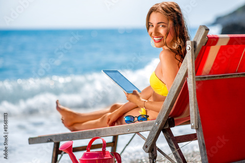 Fotografie, Tablou Woman using digital tablet on the sunbed