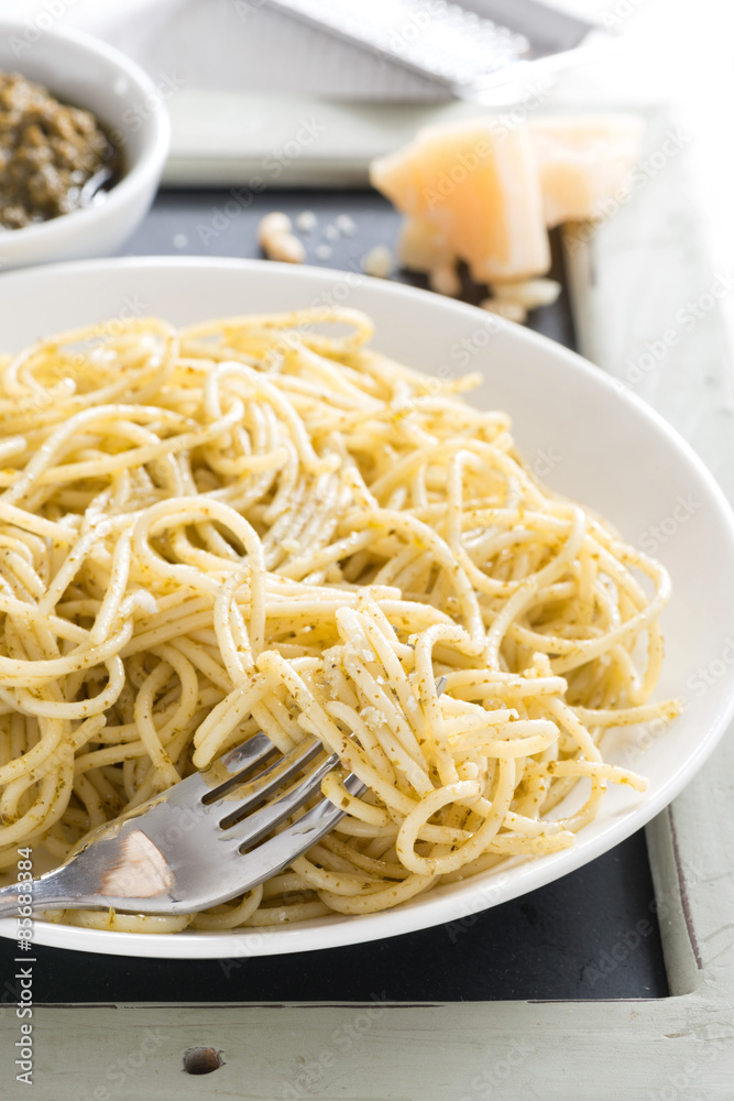 plate of spaghetti with pesto and cheese, vertical plate of spaghetti with pesto and cheese, vertical