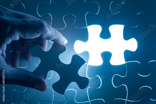 Hand insert jigsaw, conceptual image of business strategy