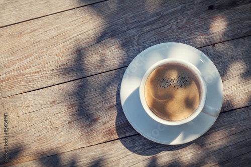 Coffee cup on sunny garden table