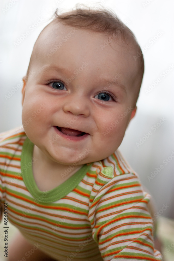 Portrait of laughing little boy with big eyes in color pajamas c Portrait of laughing little boy with big eyes in color pajamas c