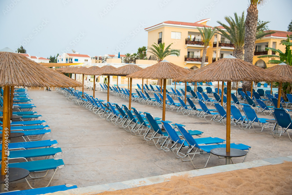 Empty sun beds at hotel swimming pool