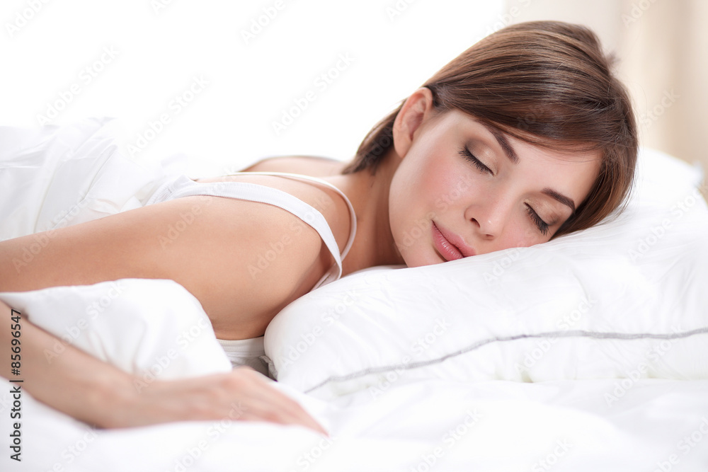 Beautiful girl sleeps in the bedroom, lying on bed Beautiful girl sleeps in the bedroom, lying on bed