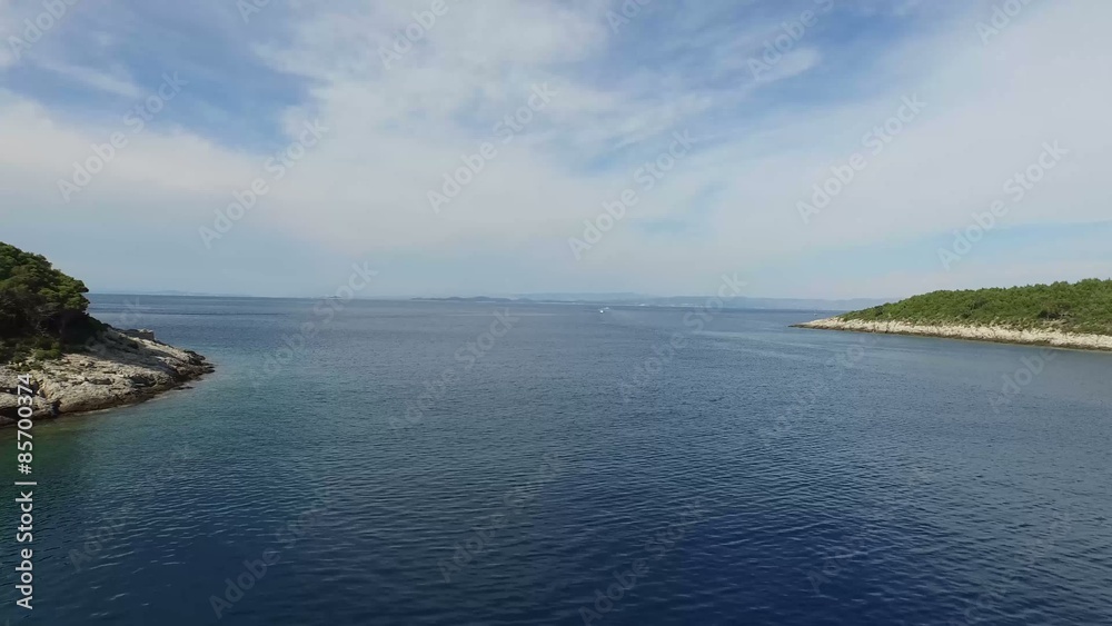 Escena dron. Viajando a través de una bahía de la costa dálmata. En ambos lados del encuadre aparece la costa rocosa. Croacia.