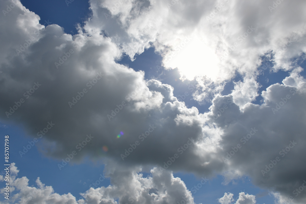 Fototapeta premium Cloudscape with the sun rays radiating from behind the rainy clo