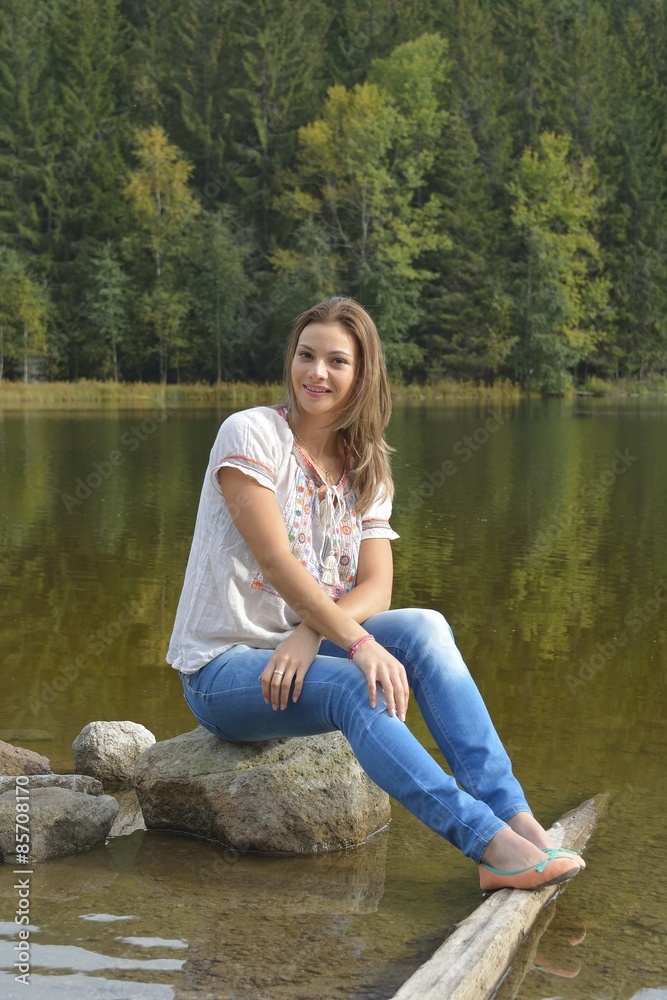 young woman sitting near a lake young woman sitting near a lake