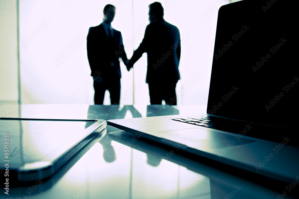 Fototapeta premium Computer on desk , businesspeople standing in the background