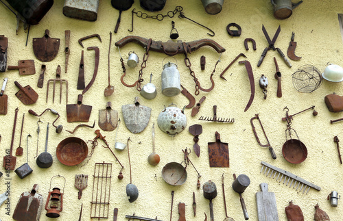 Fototapeta Naklejka Na Ścianę i Meble -  many ancient farming tools hanging on the wall