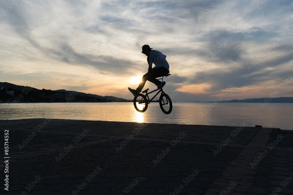 Obraz premium Bmx tricks against a dramatic sky.