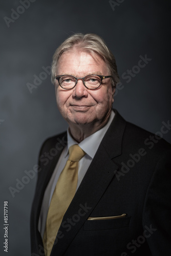 Senior businessman on dark background