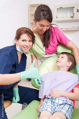 Confident dentist woman showing like with child patient