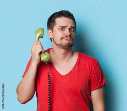 guy in t-shirt with green retro dial phone