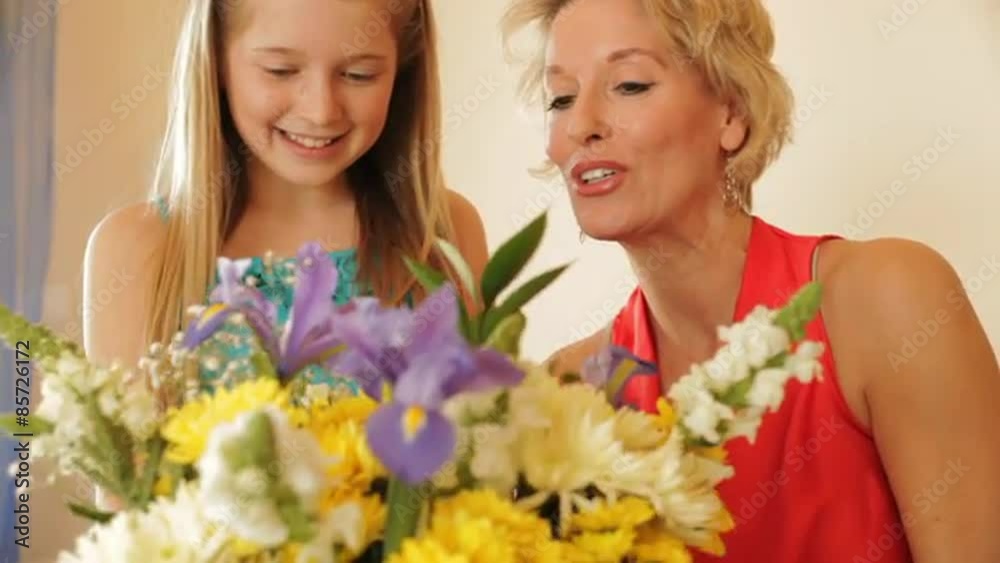 Dolly shot of grandmother and granddaughter flower arranging together indoors. Dolly shot of grandmother and granddaughter flower arranging together indoors.