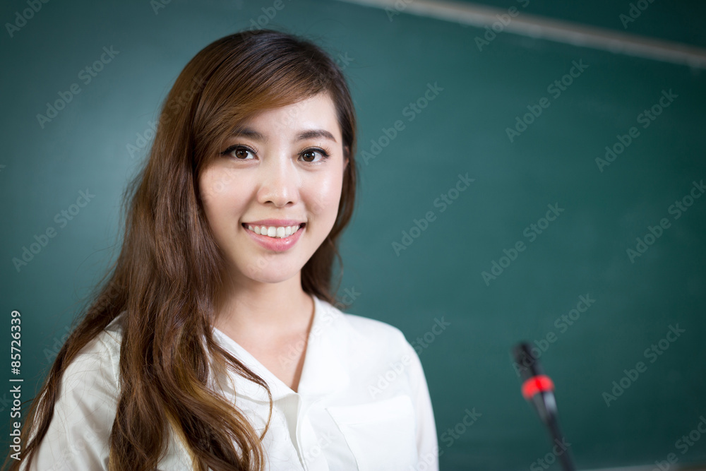 Asian beautiful woman speaking in front of blackboard with micro Asian beautiful woman speaking in front of blackboard with micro