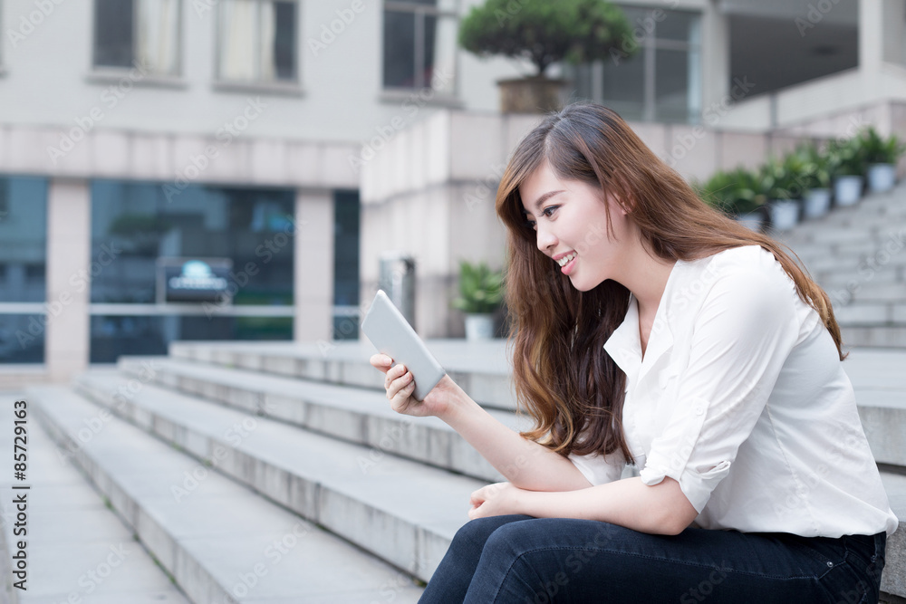 Fototapeta premium Asian female student using tablet in campus