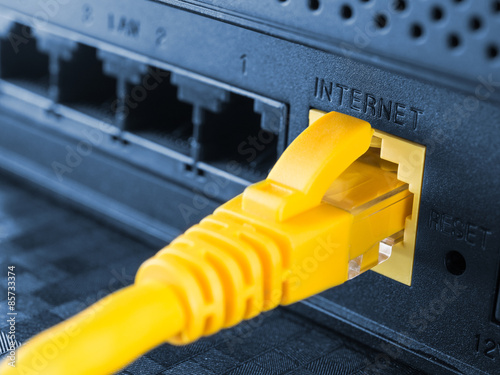 Yellow network cable connected to a router or modem