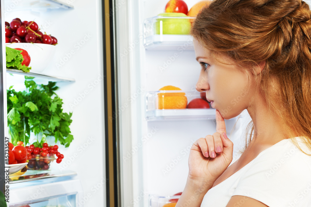 Happy woman and open refrigerator with fruits, vegetables and he
