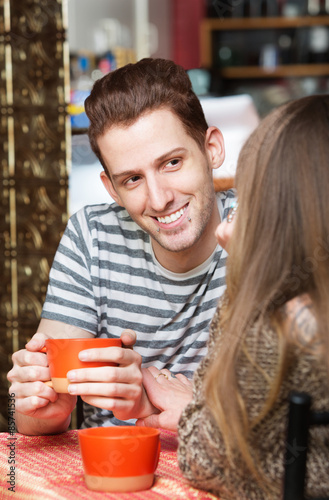 Smiling Man with Friend in Cafe