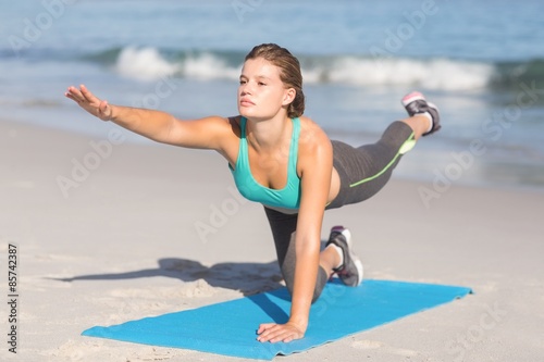 Fit woman stretching on exercise mat 