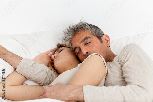 Couple sleeping in his bed